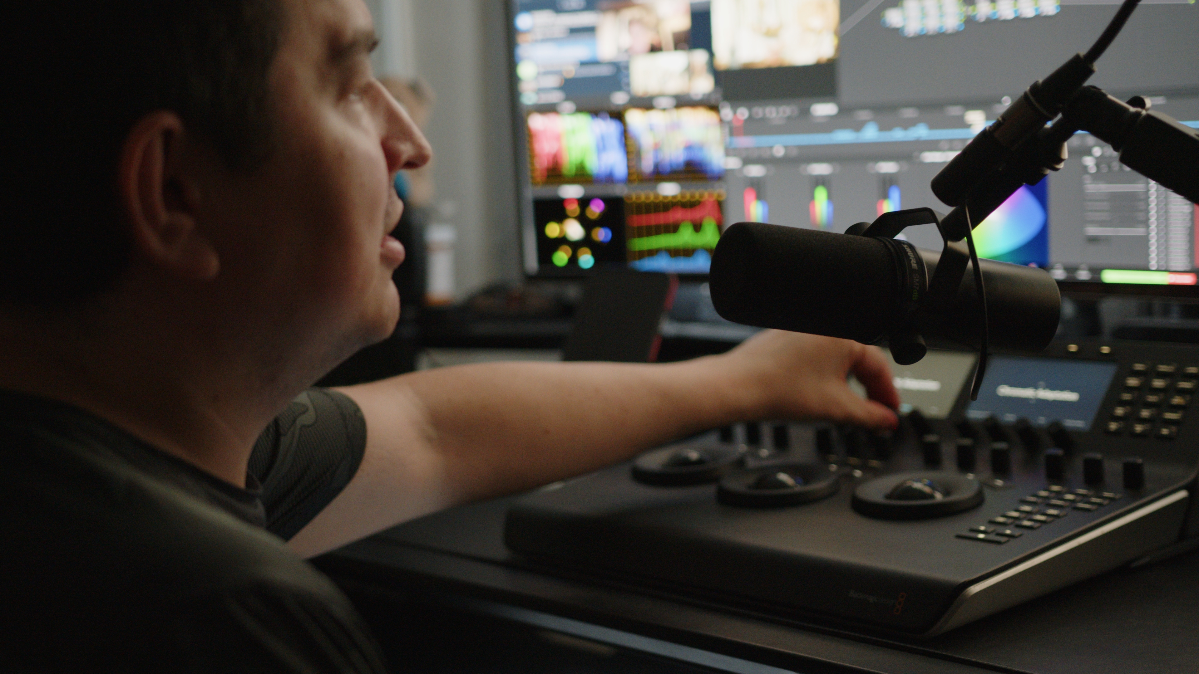 Nick in profile, adjusting the Blackmagic grading panel at his workstation